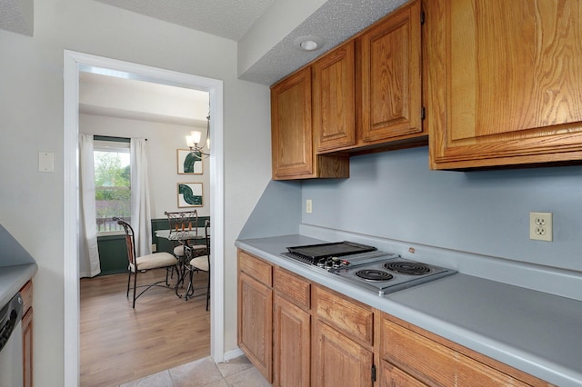 523 E Camino St, Springfield, MO 65810 - kitchen featuring brown cabinetry, stainless steel electric stovetop, light countertops, a notable chandelier, and light wood-style flooring