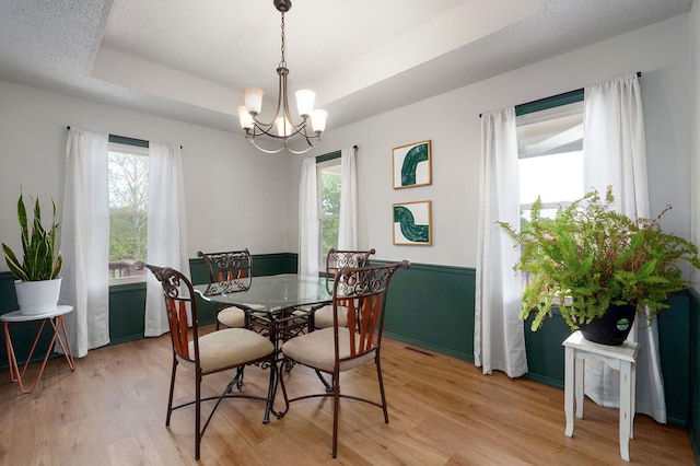 523 E Camino St, Springfield, MO 65810 - dining space featuring visible vents, light wood-type flooring, a tray ceiling, and an inviting chandelier