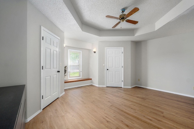 523 E Camino St, Springfield, MO 65810 - interior space featuring ceiling fan, a raised ceiling, a textured ceiling, light wood-style flooring, and baseboards