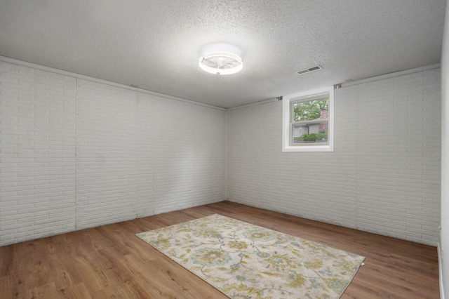 523 E Camino St, Springfield, MO 65810 - unfurnished room with wood finished floors, a textured ceiling, brick wall, and visible vents