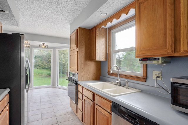 523 E Camino St, Springfield, MO 65810 - kitchen featuring light countertops, a textured ceiling, brown cabinets, a sink, and stainless steel appliances