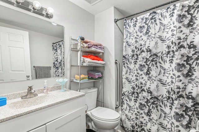 bathroom featuring vanity, toilet, curtained shower, and visible vents