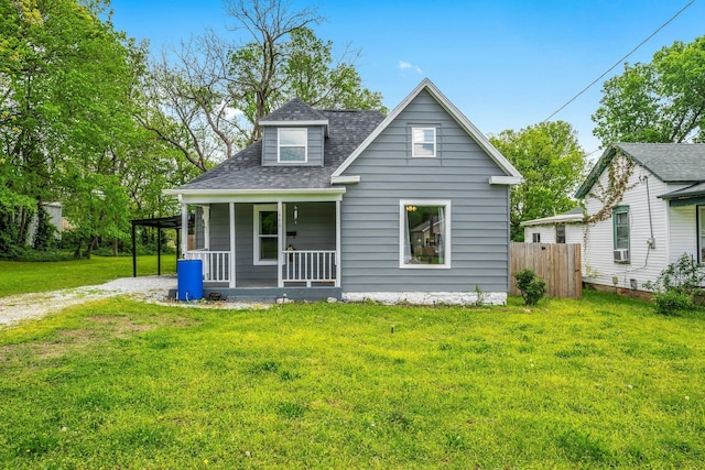 view of front of home featuring fence, a shingled roof, a front yard, covered porch, and driveway