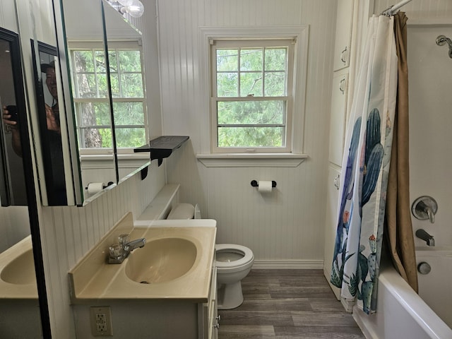 full bathroom featuring shower / bath combo, vanity, toilet, baseboards, and wood finished floors