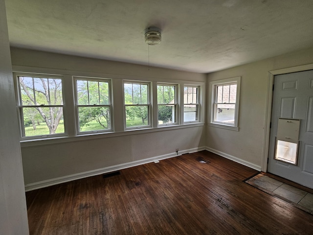 interior space featuring baseboards and dark wood-style flooring