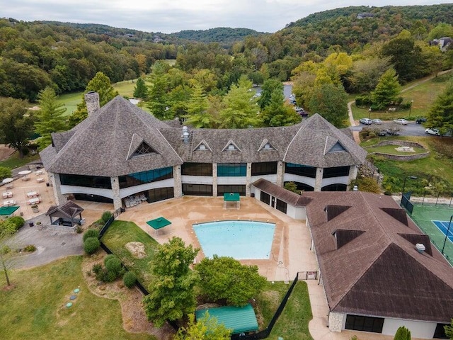 view of swimming pool featuring a forest view