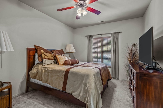 bedroom with baseboards, light colored carpet, ceiling fan, and visible vents