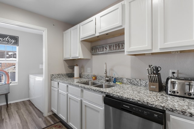 kitchen featuring a sink, dishwasher, white cabinetry, light wood-type flooring, and washer and clothes dryer