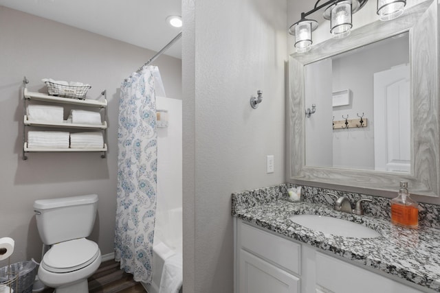 bathroom featuring toilet, wood finished floors, and vanity