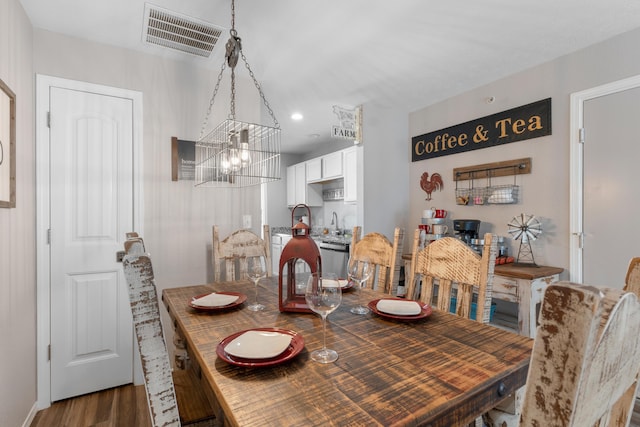 dining space featuring visible vents, recessed lighting, wood finished floors, and an inviting chandelier