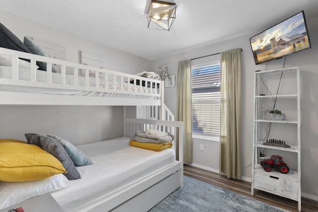 bedroom featuring baseboards and wood finished floors