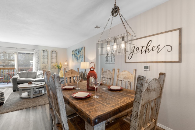 dining room with wood finished floors and a chandelier