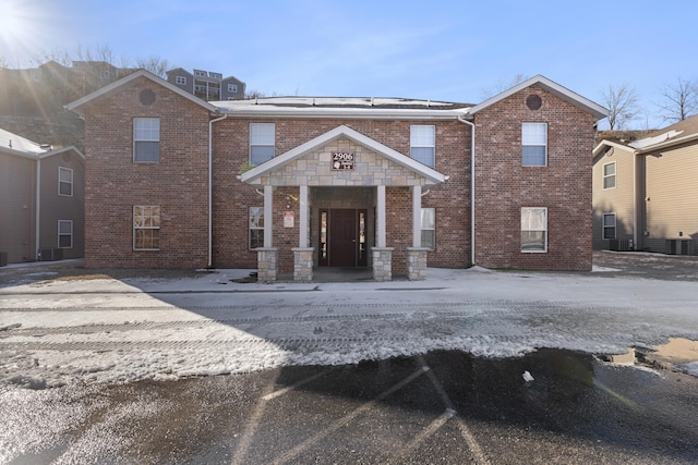 view of front of property with brick siding and central AC unit
