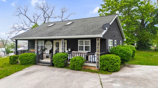 view of front facade with a porch and roof with shingles