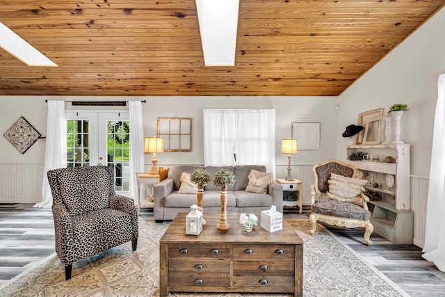 living room featuring vaulted ceiling with skylight, wood ceiling, french doors, and wood finished floors