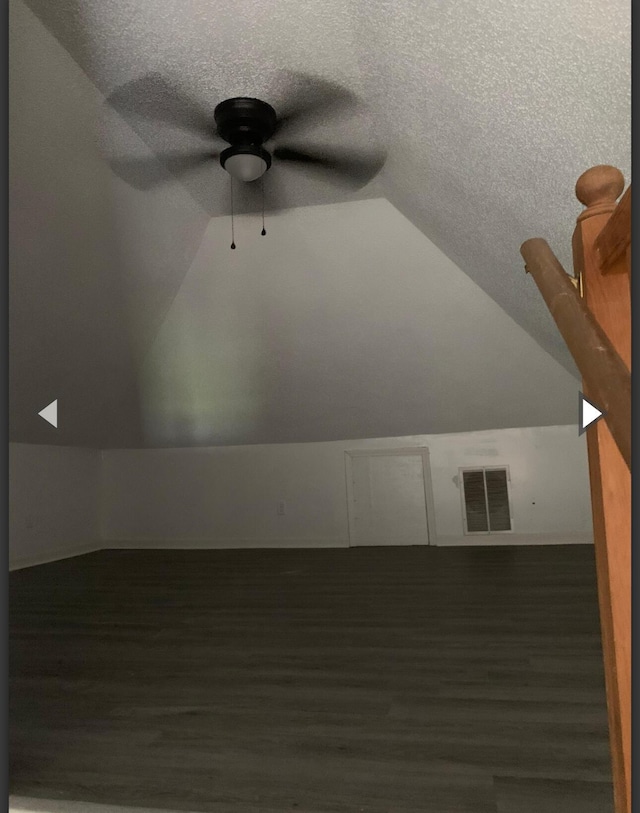 bonus room with a ceiling fan, a textured ceiling, visible vents, vaulted ceiling, and wood finished floors
