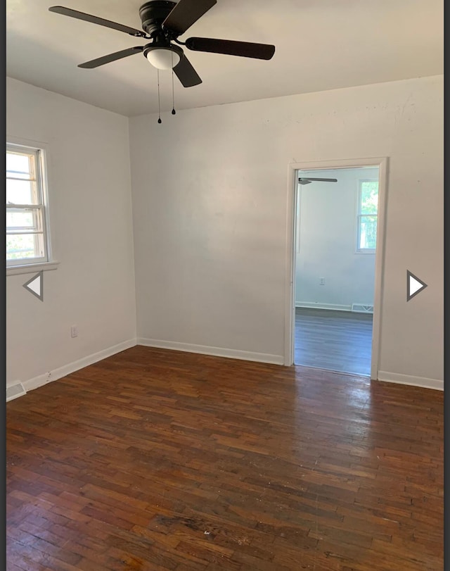 unfurnished room featuring a ceiling fan, baseboards, and dark wood-type flooring