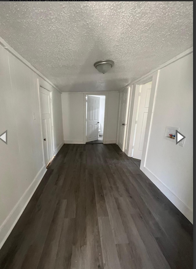 interior space featuring baseboards, dark wood-style floors, and a textured ceiling