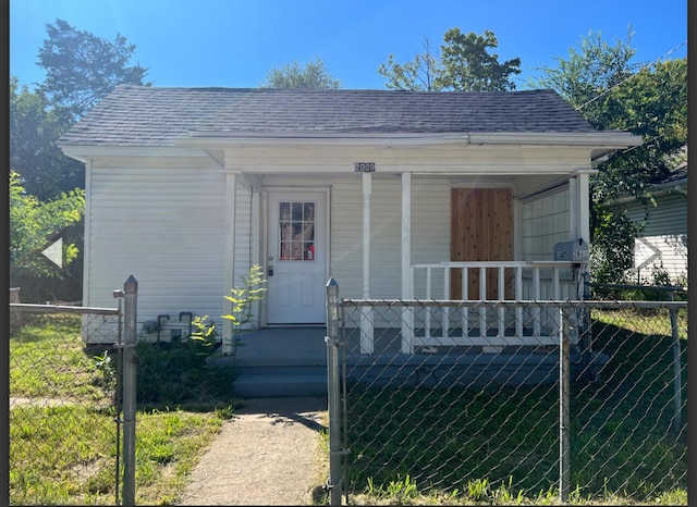 bungalow-style house with roof with shingles, fence, and covered porch