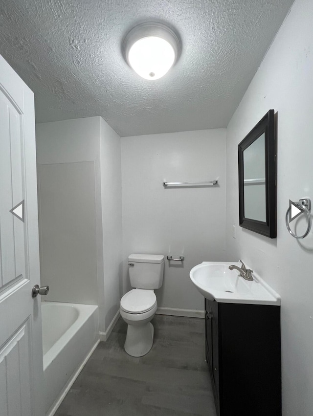 full bath with vanity, wood finished floors, toilet, baseboards, and a textured ceiling