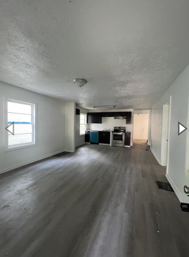 unfurnished living room featuring baseboards, dark wood-style floors, and a textured ceiling
