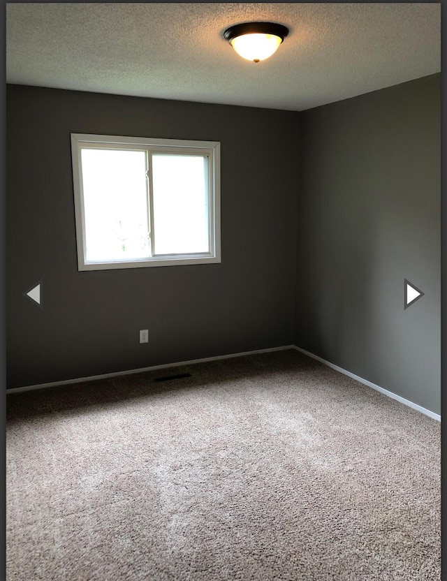 928 N Glenn Ave, Springfield, MO 65803 - spare room with a textured ceiling, baseboards, and carpet