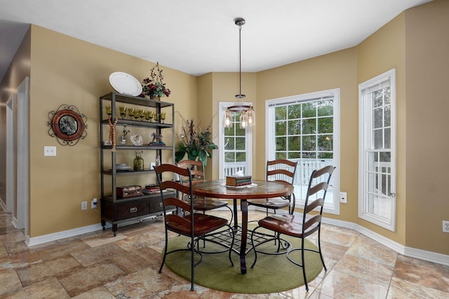 dining room with baseboards and stone finish floor