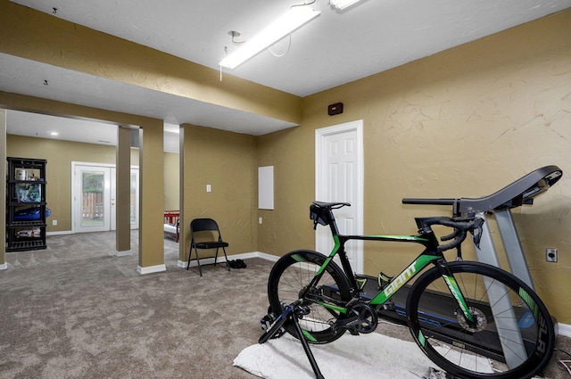 workout room with baseboards and carpet