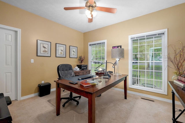 office area with light colored carpet, baseboards, ceiling fan, and visible vents