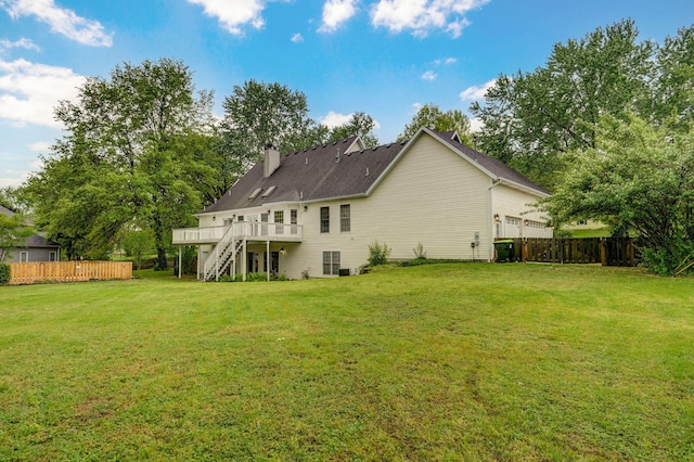 rear view of property featuring stairway, a lawn, fence, and a wooden deck