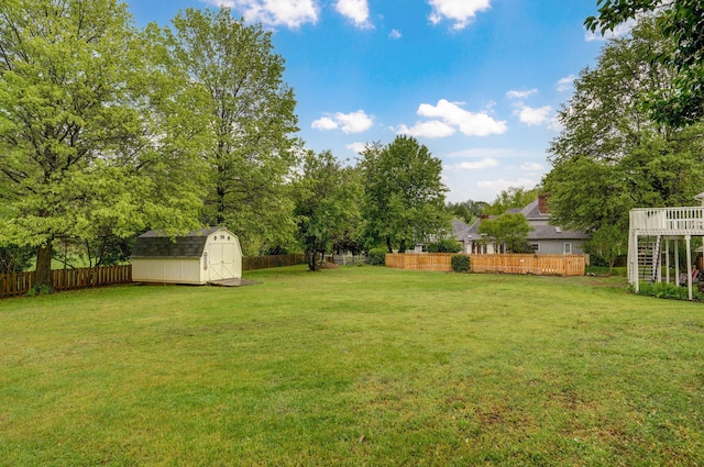 view of yard featuring a storage shed, an outbuilding, and a fenced backyard
