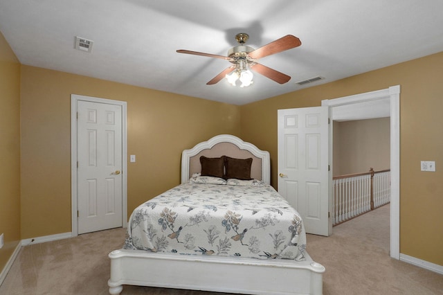 bedroom with baseboards, visible vents, and light carpet