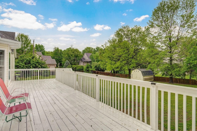 deck with a storage unit, a fenced backyard, a yard, and an outdoor structure