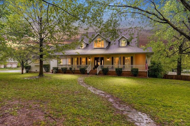 view of front of property featuring a garage, a front lawn, fence, a porch, and driveway