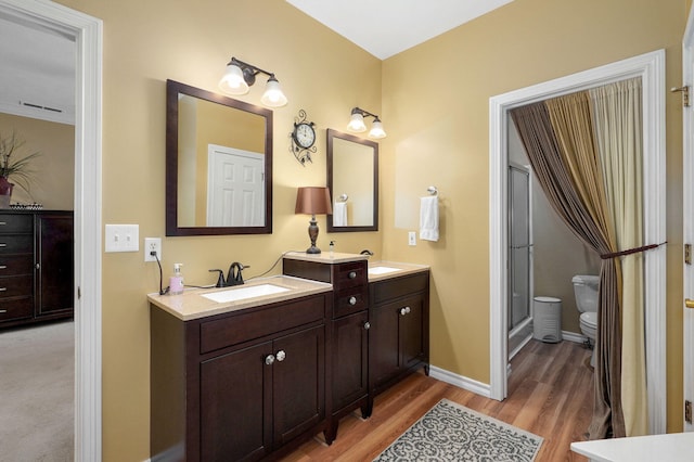 bathroom featuring visible vents, wood finished floors, vanity, baseboards, and toilet