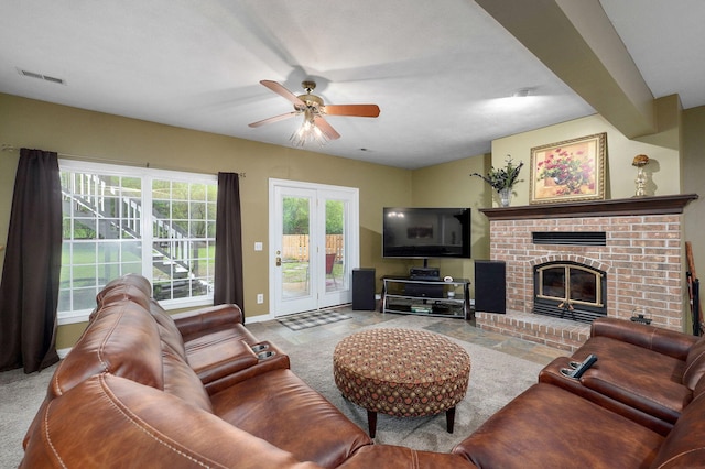 living room with visible vents, carpet flooring, ceiling fan, and a fireplace