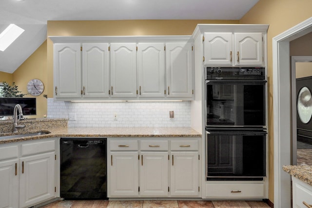 kitchen featuring light stone countertops, white cabinets, tasteful backsplash, a sink, and black appliances