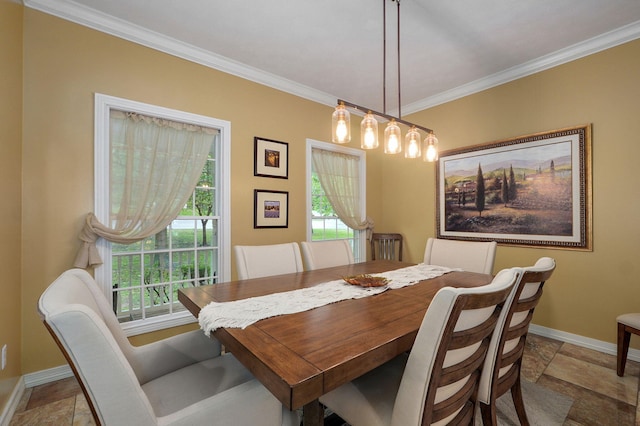 dining area with stone tile flooring, ornamental molding, and baseboards