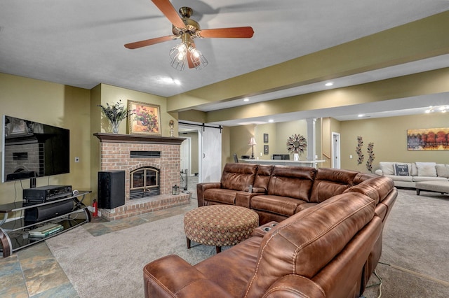 living area featuring a brick fireplace, recessed lighting, a ceiling fan, decorative columns, and stone finish flooring