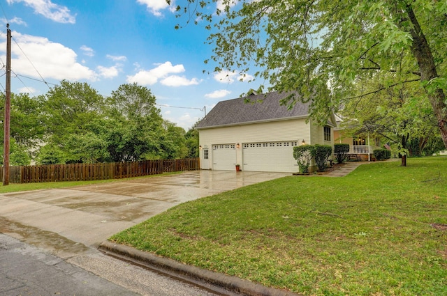 view of home's exterior with a lawn, fence, and concrete driveway