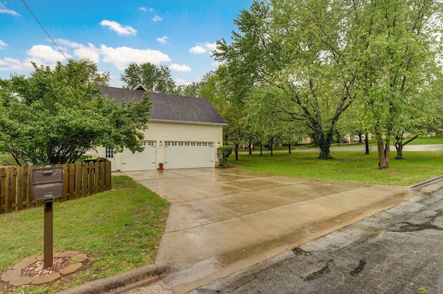 view of property exterior with an attached garage, fence, roof with shingles, a lawn, and driveway