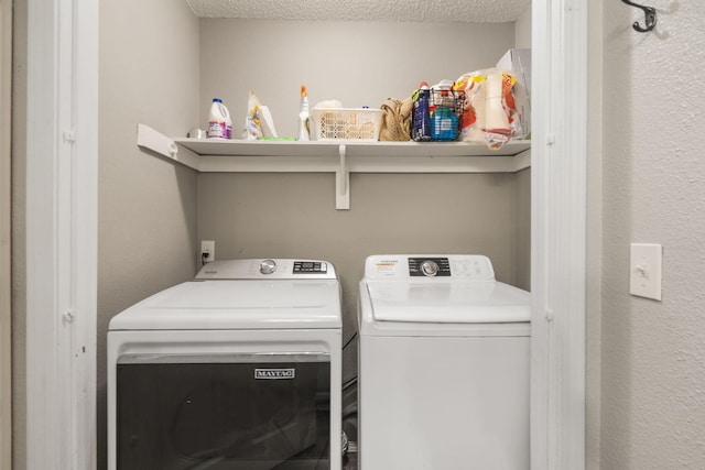 laundry area with laundry area, a textured ceiling, and washing machine and clothes dryer