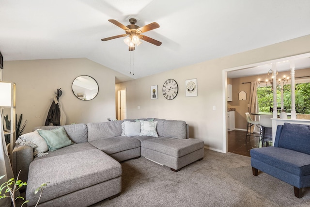 carpeted living area with baseboards, ceiling fan with notable chandelier, and vaulted ceiling