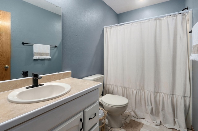 full bath featuring vanity, a textured wall, a shower with shower curtain, and toilet