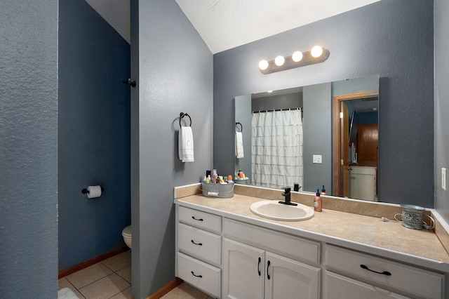 full bath with a textured wall, tile patterned flooring, vanity, toilet, and vaulted ceiling