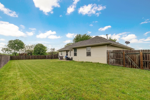 back of house with a lawn and a fenced backyard