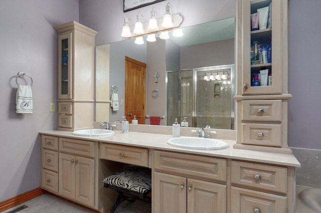 bathroom featuring double vanity, a sink, a stall shower, and visible vents