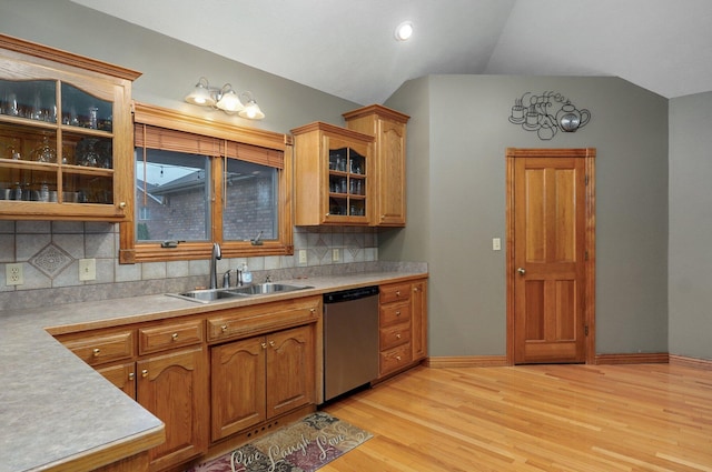 kitchen featuring tasteful backsplash, dishwasher, a sink, light countertops, and light wood finished floors