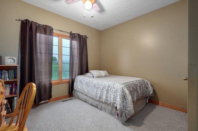 carpeted bedroom featuring baseboards and ceiling fan