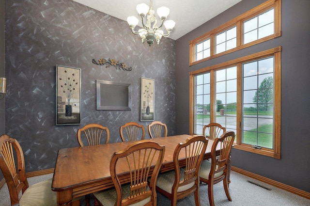 carpeted dining room featuring baseboards, a chandelier, wallpapered walls, and visible vents